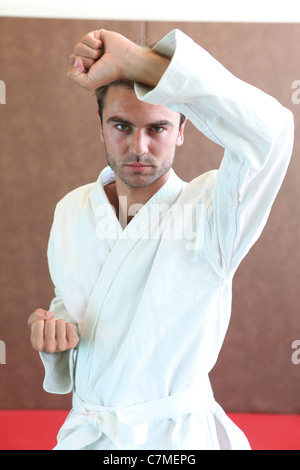 Homme portant des vêtements d'arts martiaux se leva en position de défense Banque D'Images