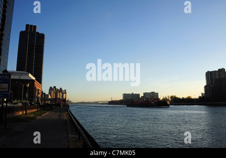 Voir tôt le matin, en direction de Robert Kennedy, pont barge cargo passé à Roosevelt Island, West Channel East River, New York Banque D'Images