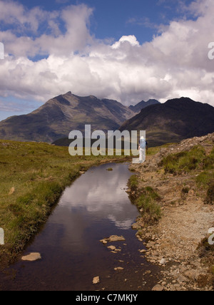 Seule femme randonneur sur le chemin d'Camasunary bay avec Black Cuillin Mountain Ridge dans la distance, Isle of Skye, Scotland, UK Banque D'Images