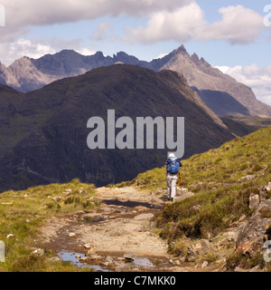 Seule femme randonneur sur le chemin d'Camasunary bay avec Black Cuillin Mountain Ridge dans la distance, Isle of Skye, Scotland, UK Banque D'Images