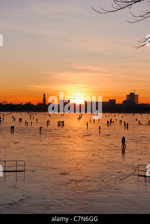 Congelés fermement, l'Aussenalster Lac Alster, après le coucher du soleil, les gens, l'amusement, glace, neige, hiver, Hambourg, Allemagne Banque D'Images