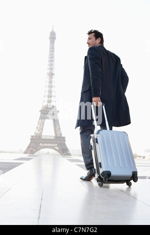 Businessman walking avec assurance avec la Tour Eiffel en arrière-plan, Paris, Ile-de-France, France Banque D'Images