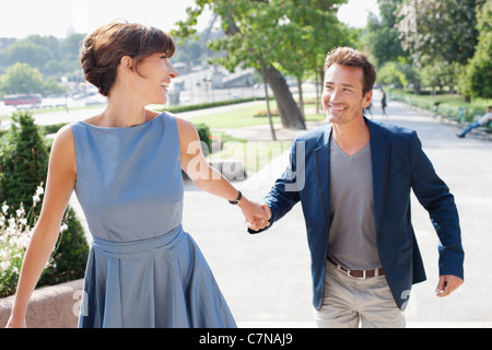 Couple en train de marcher sur une passerelle dans un jardin, Tour Eiffel, Paris, Ile-de-France, France Banque D'Images
