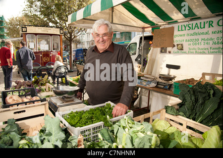 A smiling exposant vend ses légumes produits localement au Salon de l'alimentation, Aberystwyth, Pays de Galles, Royaume-Uni, Septembre 2011 Banque D'Images