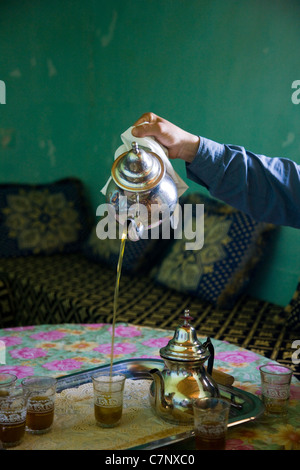 Thé à la menthe sucré marocain est versé dans un verre d'une théière en argent Banque D'Images