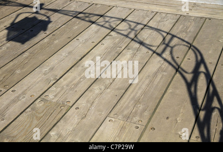 Le soleil projette l'ombre d'une arche en fer forgé et de la lanterne sur un trottoir. Banque D'Images