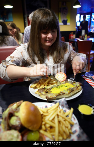 Femme de savourer la malbouffe malsaine Banque D'Images