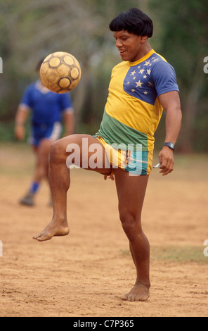 Brésilien Yaulapiti acculturés indiennes autochtones jouent au football et porte maillot de l'équipe de football du Brésil et regarder Amazon Xingu Banque D'Images