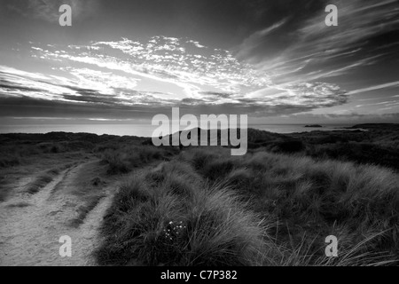 Seascape à Gwithian Cornwall sur les dunes de sable et sur la mer. Soleil du soir, coucher de soleil sur la mer. Une photographie en noir et blanc Banque D'Images