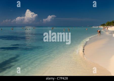 Les nageurs dans les eaux bleu calme sur la plage de sable blanc de la Riviera Maya Resort au Mexique Banque D'Images