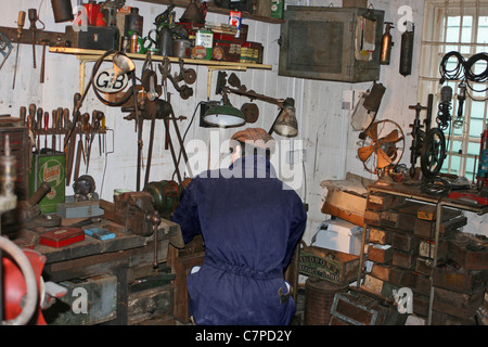 L'homme travaillant en 1960 atelier/garage avec outils Banque D'Images