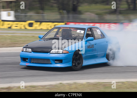 Voiture Nissan Skyline R32 d'effectuer une dérive latérale avec la fumée des pneus dans une dérive motorsport la concurrence. Banque D'Images