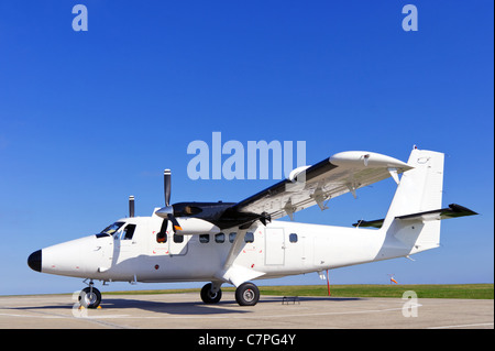 Photo d'un avion deux hélices à l'arrêt sur la piste sur une journée ensoleillée avec ciel bleu clair. Banque D'Images