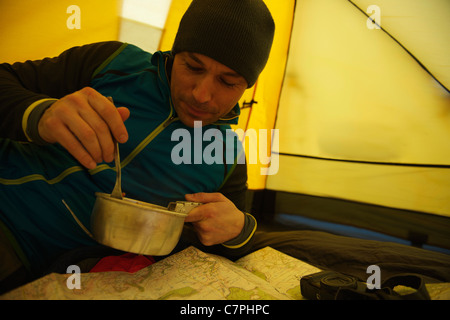 Man eating dans tente de camping Banque D'Images