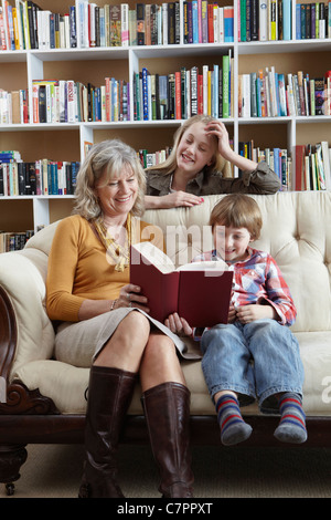 Femme et petits-enfants lire ensemble Banque D'Images