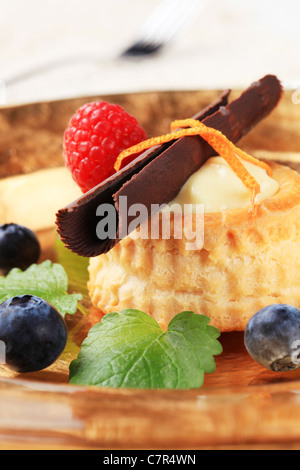 Pâte feuilletée remplie de crème garni de fruits frais avec shell Banque D'Images