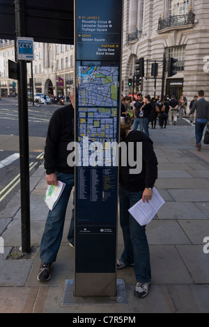 Deux visiteurs de Londres lire une carte dans la direction de la rue du capital de Regent Street. Banque D'Images