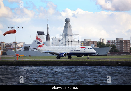 Boeing 318 de British Airways à l'aéroport de London City avec un destroyer de Type 45 de la Royal Navy dans l'arrière-plan Banque D'Images