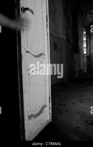 Main sur une porte de chambre manoir abandonné Banque D'Images