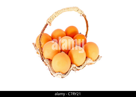 Les oeufs de poule dans un panier fait de matériaux naturels, isolé Banque D'Images