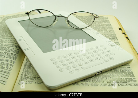 E-Livre blanc assis sur un vieux livre papier ouvert avec des lunettes Banque D'Images