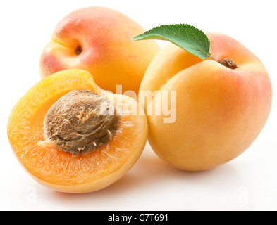 Les abricots avec des feuilles sur un fond blanc. Banque D'Images