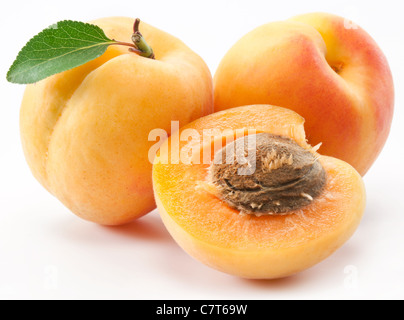 Les abricots avec des feuilles sur un fond blanc. Banque D'Images