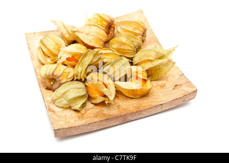 Physalis les fruits sur un plat en bois sur fond blanc Banque D'Images