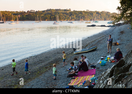 Les personnes bénéficiant d'une soirée pique-nique sur les rives de la rivière Helford près de Cornwall, Durgan Banque D'Images