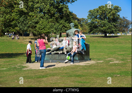 Fête de l'école posant avec Henry Moore violée "Femme assise" dans le Yorkshire Sculpture Park, Wakefield, West Yorkshire, Angleterre Banque D'Images