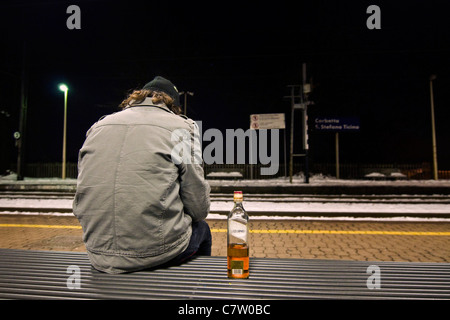 Teenage boy avec bouteille de whisky Banque D'Images