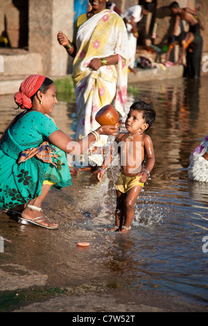 Femme indienne lave son fils. Tungabhadra river. Hampi Karnataka. L'Inde Banque D'Images