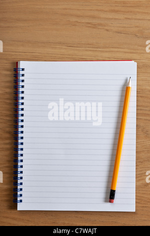 Photo d'un blanc a jugé le bloc-notes et crayon sur un bureau, ajouter votre propre copie. Banque D'Images