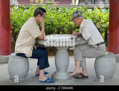 Deux hommes jouant aux échecs chinois chinois en place publique reste la rue Garden, Kowloon, Hong Kong Banque D'Images