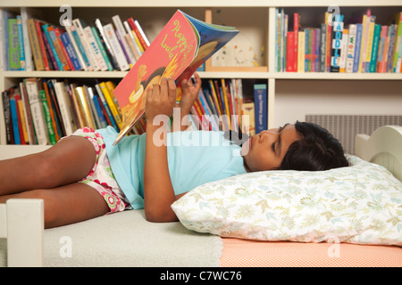 Young Girl reading in bed Banque D'Images