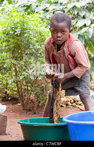 Jeune garçon tanzanien lessive à la main dans des seaux en plastique, Mrimbo Uuwo, Moshi, Tanzanie, Banque D'Images