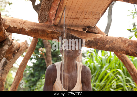 Un homme pit sciant un journal pour faire du bois, Mwika, Moshi, Tanzanie Banque D'Images