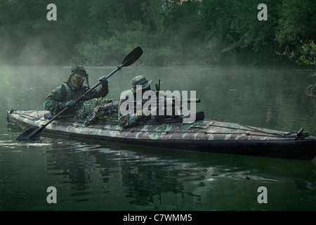 Navy SEALs naviguer les eaux dans un kayak pliant lors des opérations de guerre dans la jungle. Banque D'Images