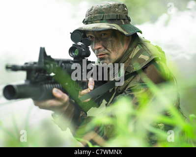 Soldat des forces spéciales américaines au moyen de patrouilles d'herbe haute pendant le combat. Banque D'Images