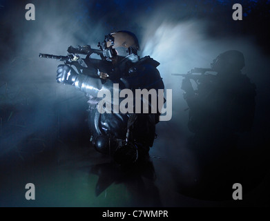 Des plongeurs de combat des Forces d'opérations spéciales en commun les eaux armés de fusils d'assaut Steyr AUG. Banque D'Images