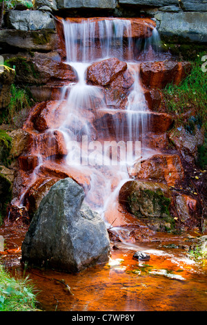 Les eaux en cascade d'une belle cascade couler sur les pierres couvertes d'algues rouges dans Andrew Haydon Park à Ottawa (Ontario) C Banque D'Images