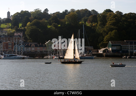 Vue de la rivière Dart, yacht rétroéclairé et Dartmouth Naval College, de l'eau, voile, nautisme, lumineux, couleurs vives, chalet, calme, coloré, Banque D'Images