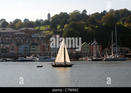 Vue de la rivière Dart, yacht rétroéclairé et Dartmouth Naval College, de l'eau, voile, nautisme, lumineux, couleurs vives, chalet, calme, coloré, Banque D'Images