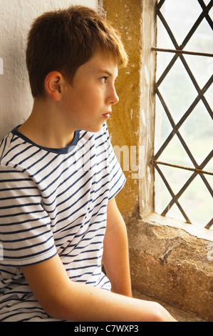 Un jeune garçon regarde par une fenêtre à Bolton Castle près de Leyburn dans Yorkshire du Nord, en Angleterre, Grande-Bretagne, Royaume-Uni Banque D'Images