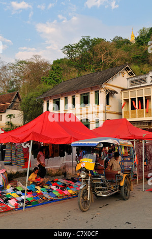 La préparation des vendeurs pour vendre les vêtements, les arts et d'artisanat sur le populaire marché de nuit de Luang Prabang au Laos Banque D'Images