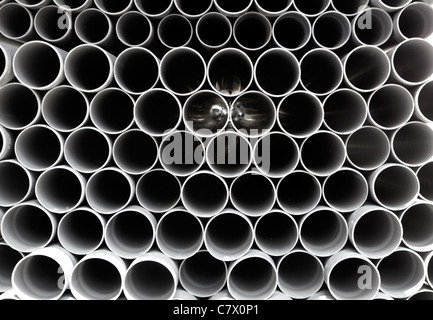 Tubes en PVC gris tuyaux en plastique empilés en rangées pattern Banque D'Images