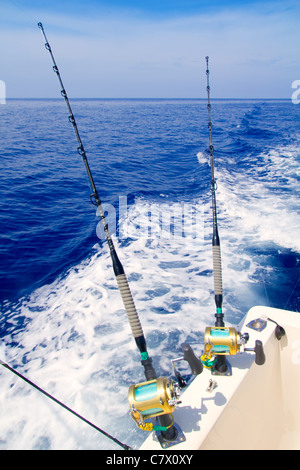 Bateau de pêche à la traîne dans la mer d'un bleu profond avec des cannes et moulinets Banque D'Images