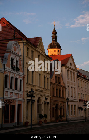 La tour de Sankt Nikolai church à Cottbus, Allemagne de l'Est, d'être éclairée par le soleil de l'après-midi derrière une rangée de maisons historiques Banque D'Images