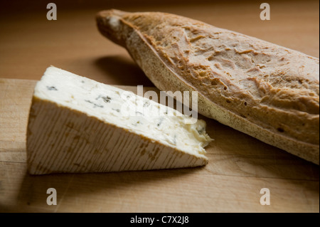 Le pain et le fromage sur une planche en bois en contre-jour. Banque D'Images