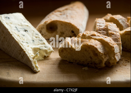 Le pain et le fromage sur une planche en bois en contre-jour. Banque D'Images